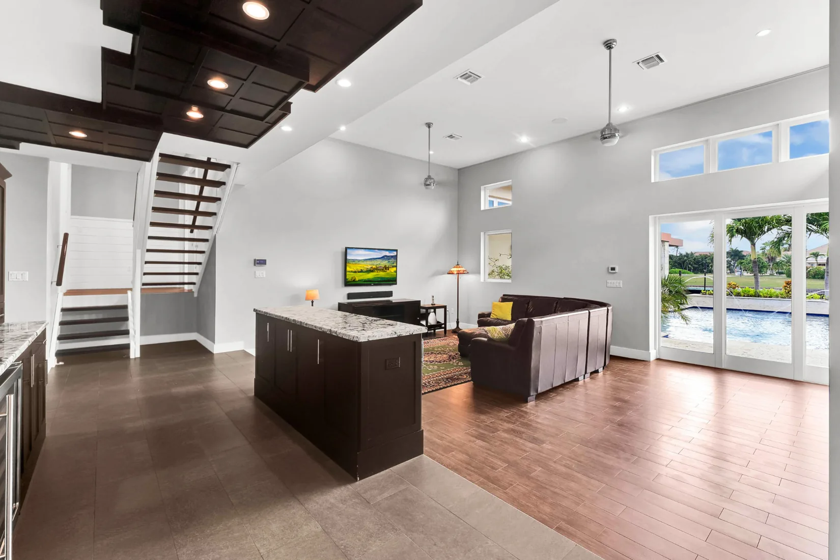 Open-plan living room with a dark island and a pool view in Grand Cayman
