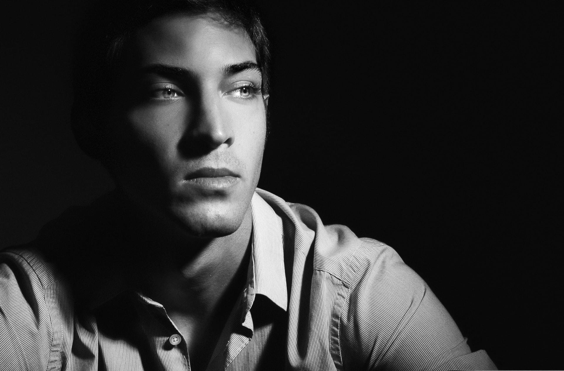 Black and white editorial portrait in dramatic light