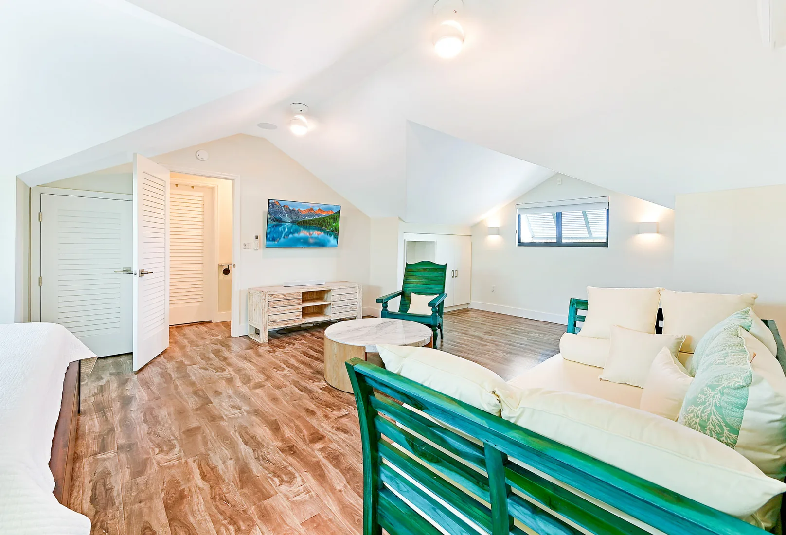 Loft bedroom with a teal daybed and seafoam cushions in Grand Cayman