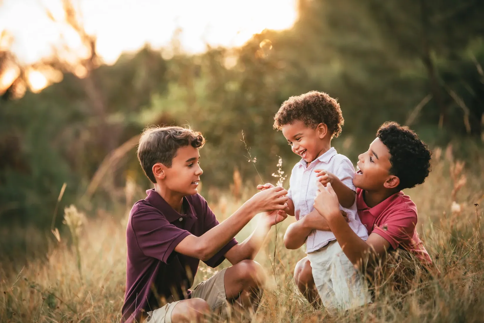 Father playing with his sons in golden grass in Grand Cayman