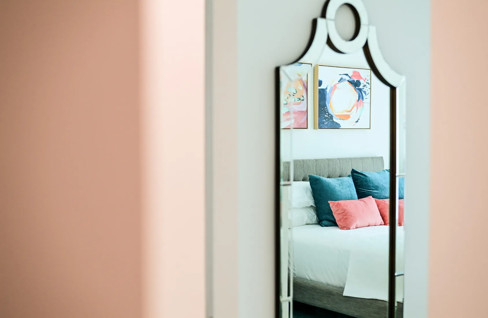 Mirror reflecting a bedroom with colourful paintings in Grand Cayman
