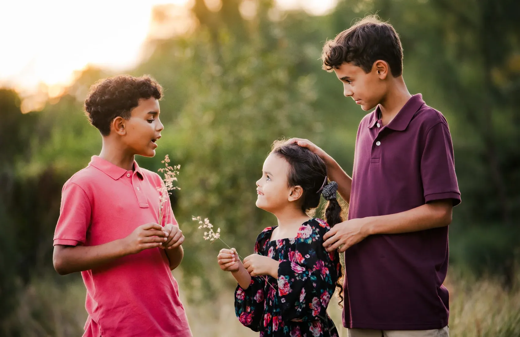 Children laughing together in golden grass in Grand Cayman