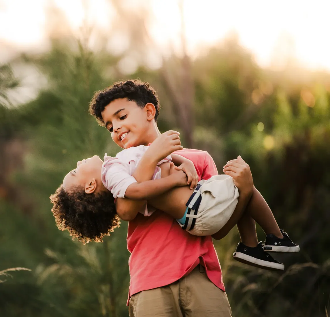 Father lifting his young son in golden grass in Grand Cayman