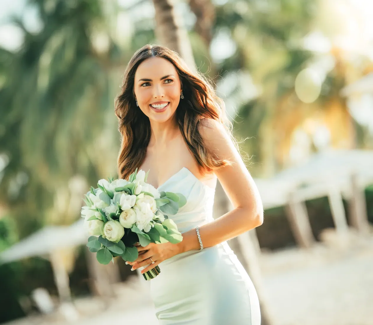 Bride holding a bouquet beneath palms in Grand Cayman