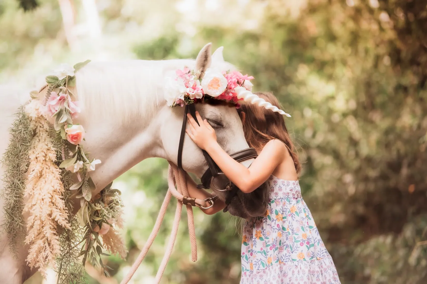 Young girl embracing a flower-adorned white horse