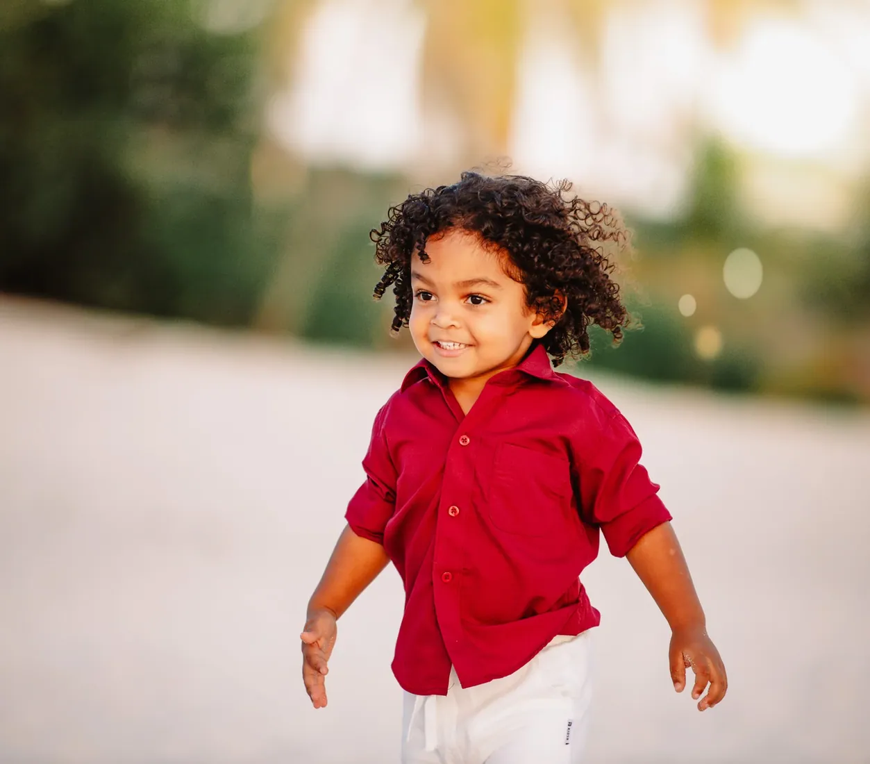 Little boy in a red shirt beneath trees in Grand Cayman