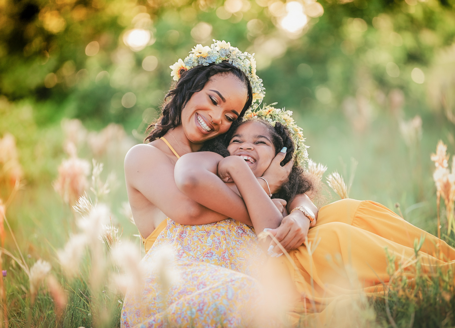 Mother and child in flower crowns in a sunlit meadow