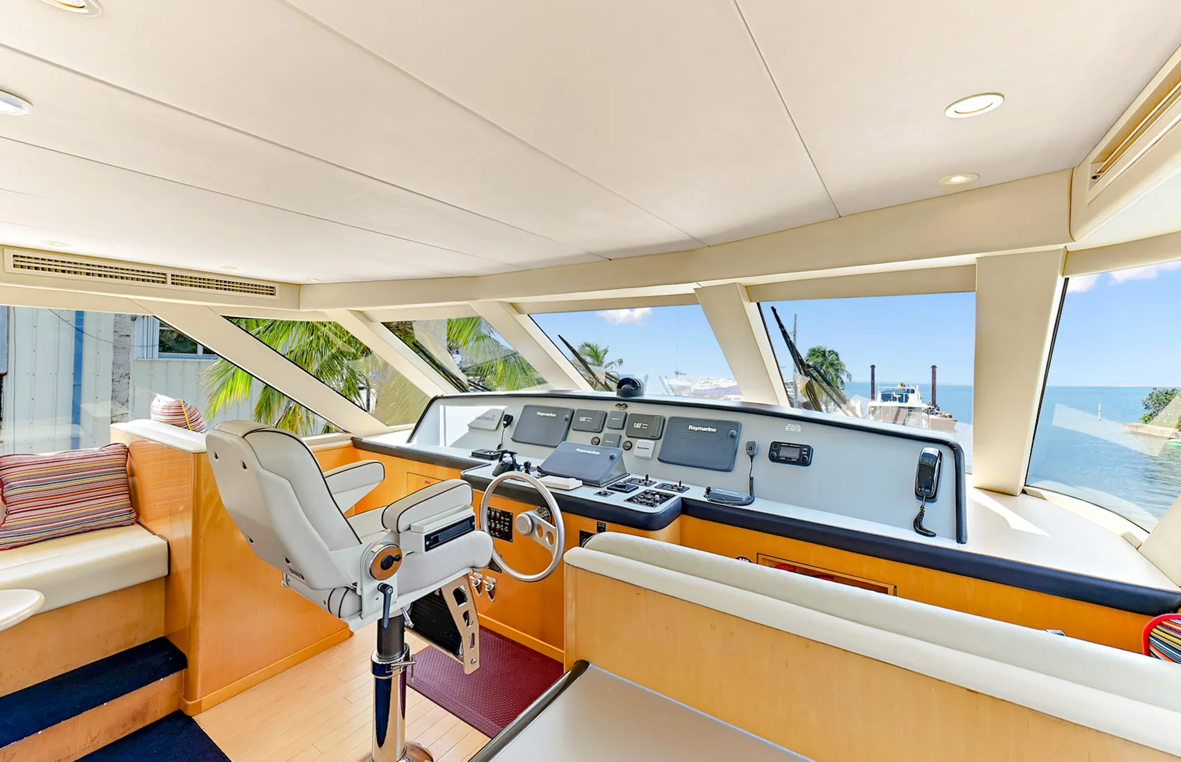 Yacht helm station with a steering wheel overlooking turquoise water in Grand Cayman