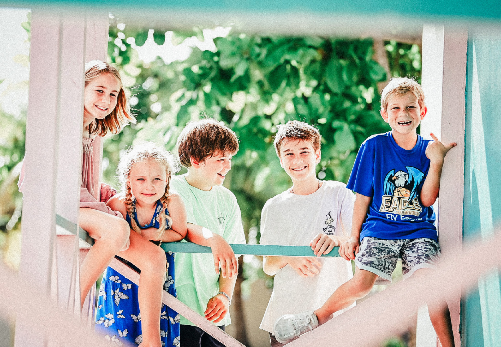 Children smiling together on a porch in Grand Cayman
