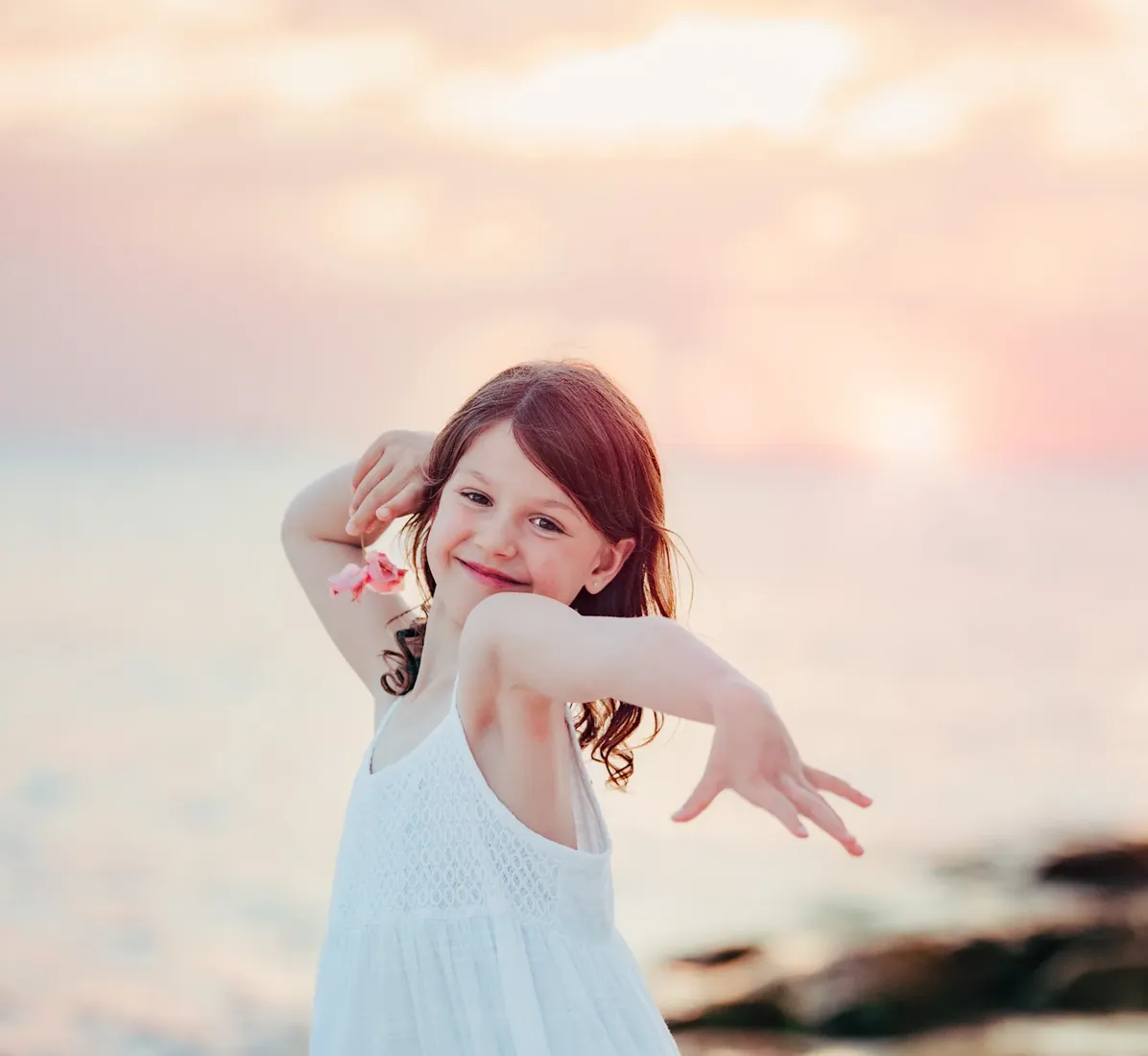 Girl reaching towards the camera at sunset on the beach in Grand Cayman