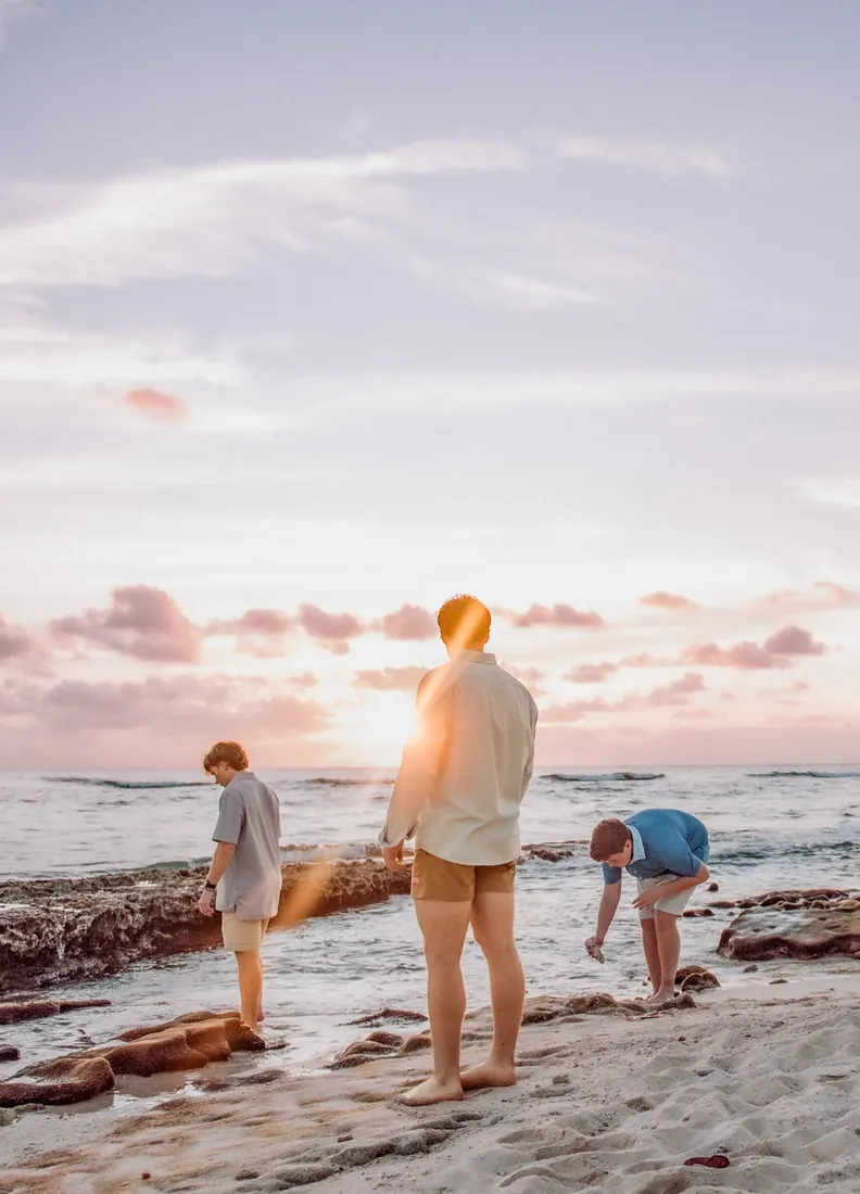 Family looking towards the sunset shoreline in Grand Cayman