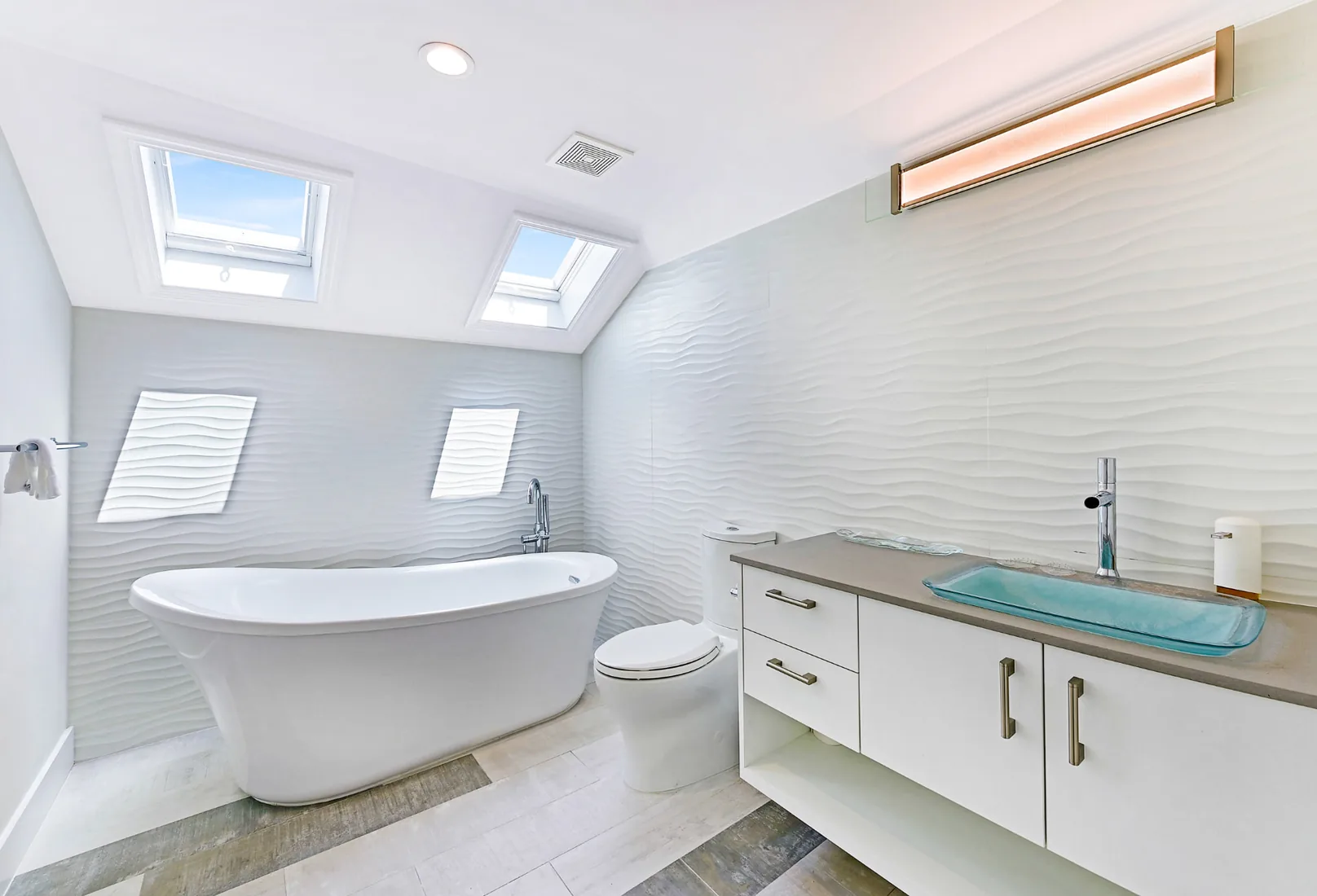 Vaulted bathroom with a freestanding tub and a seafoam glass sink in Grand Cayman