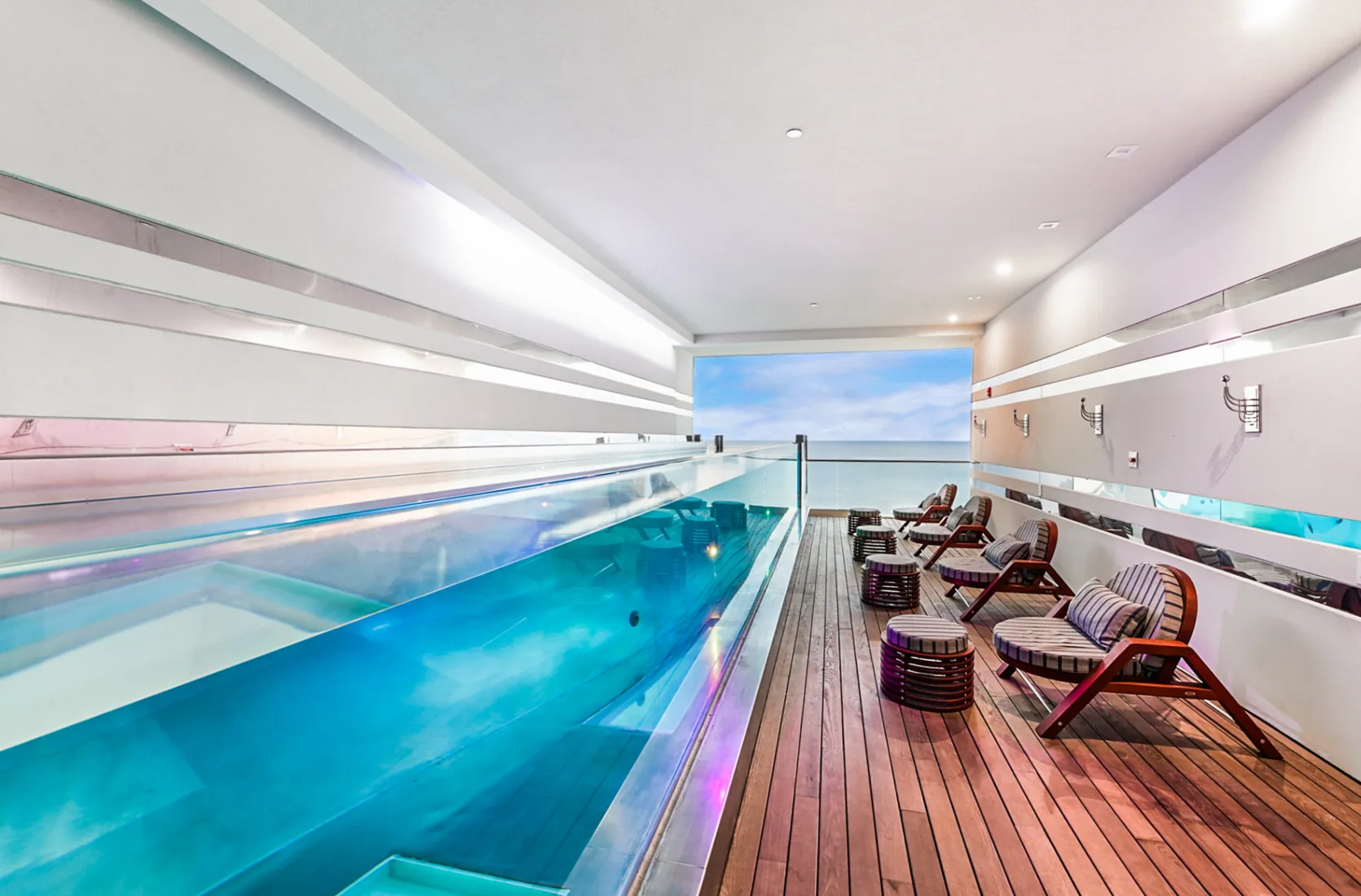 Rooftop lap pool with a glass side wall above the sea in Grand Cayman