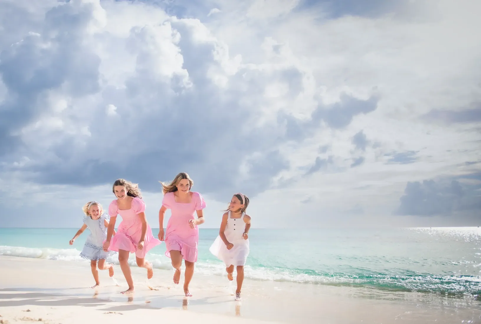 Family walking along the shore under a blue sky in Grand Cayman
