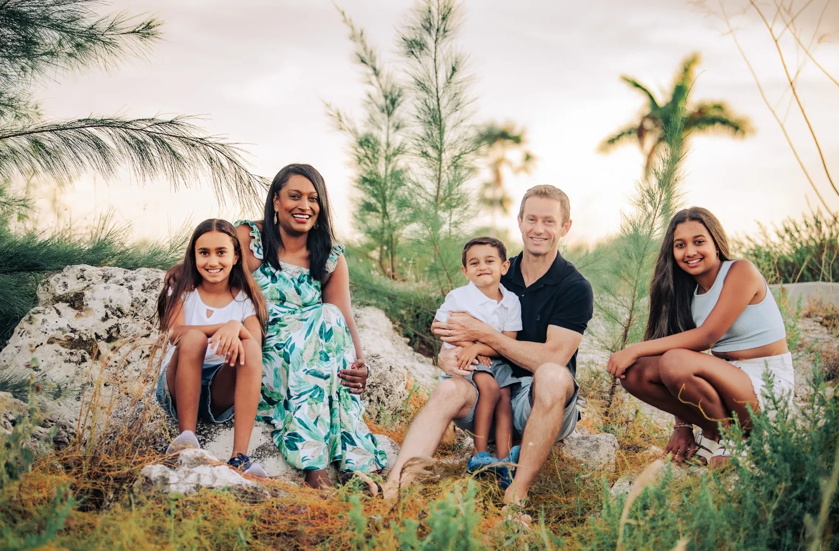 Family seated together beneath palms in Grand Cayman