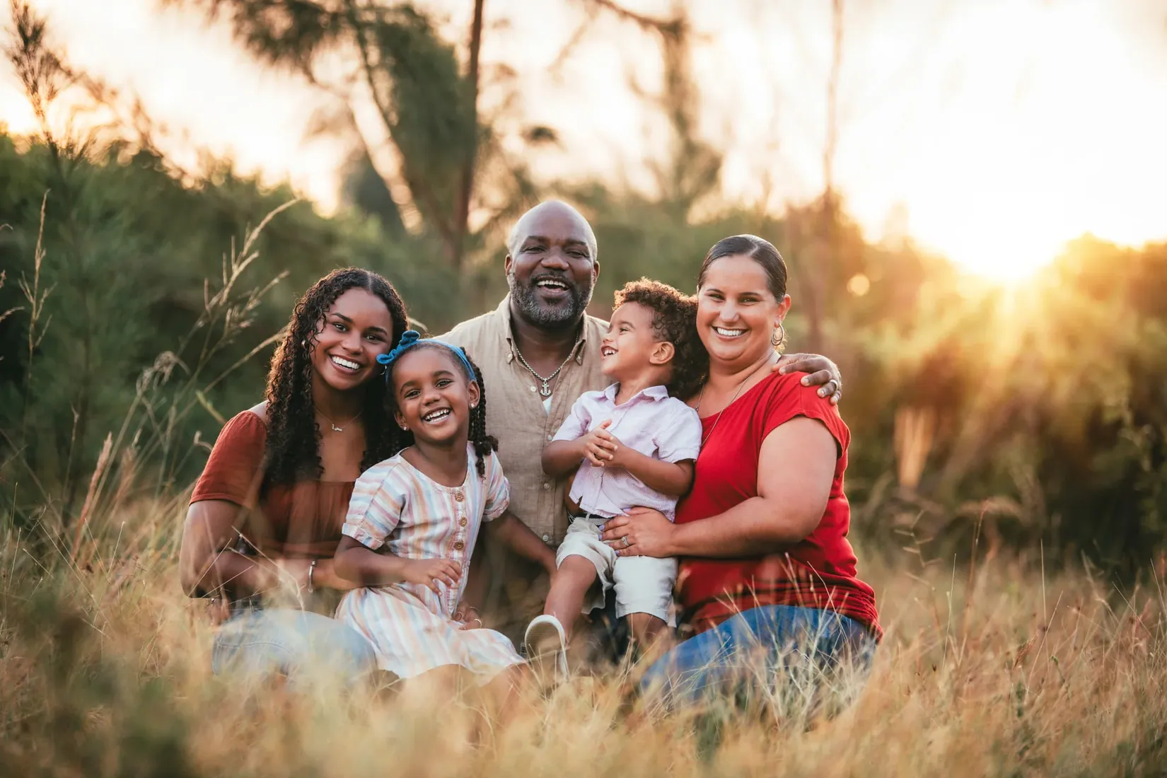 Family seated in a golden meadow in Grand Cayman
