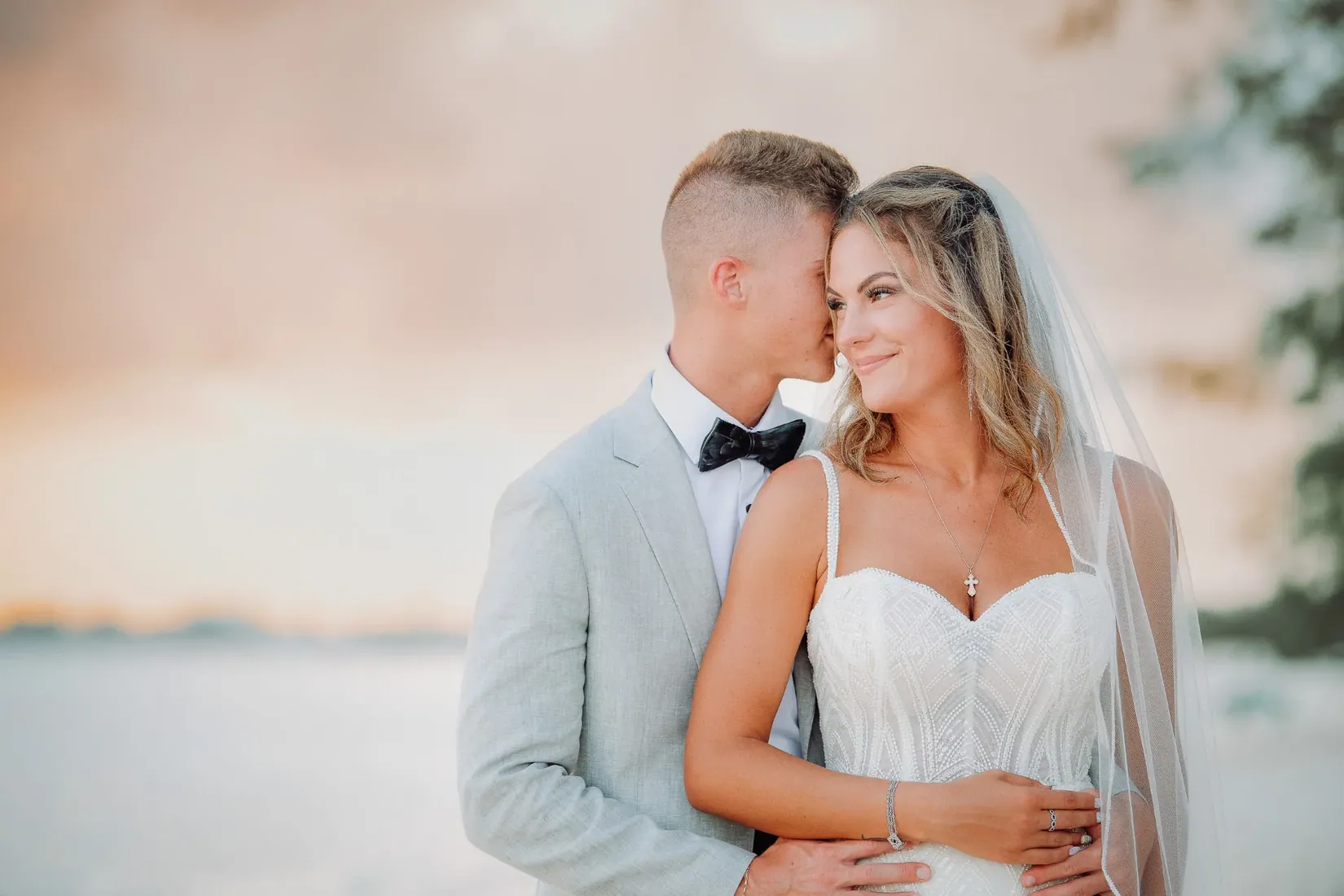 Groom kissing the bride beside the sea in Grand Cayman