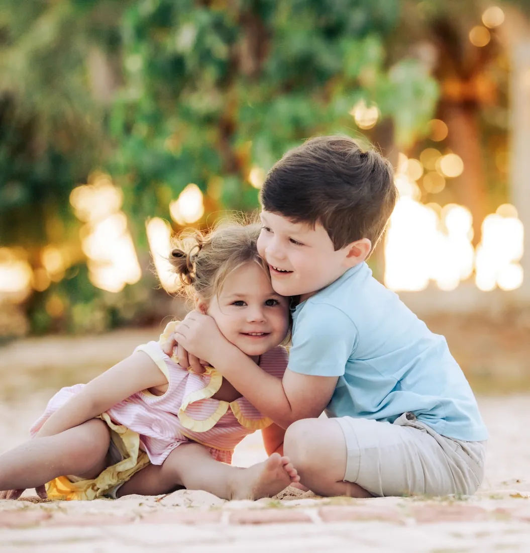 Father cuddling his young daughter outdoors in Grand Cayman