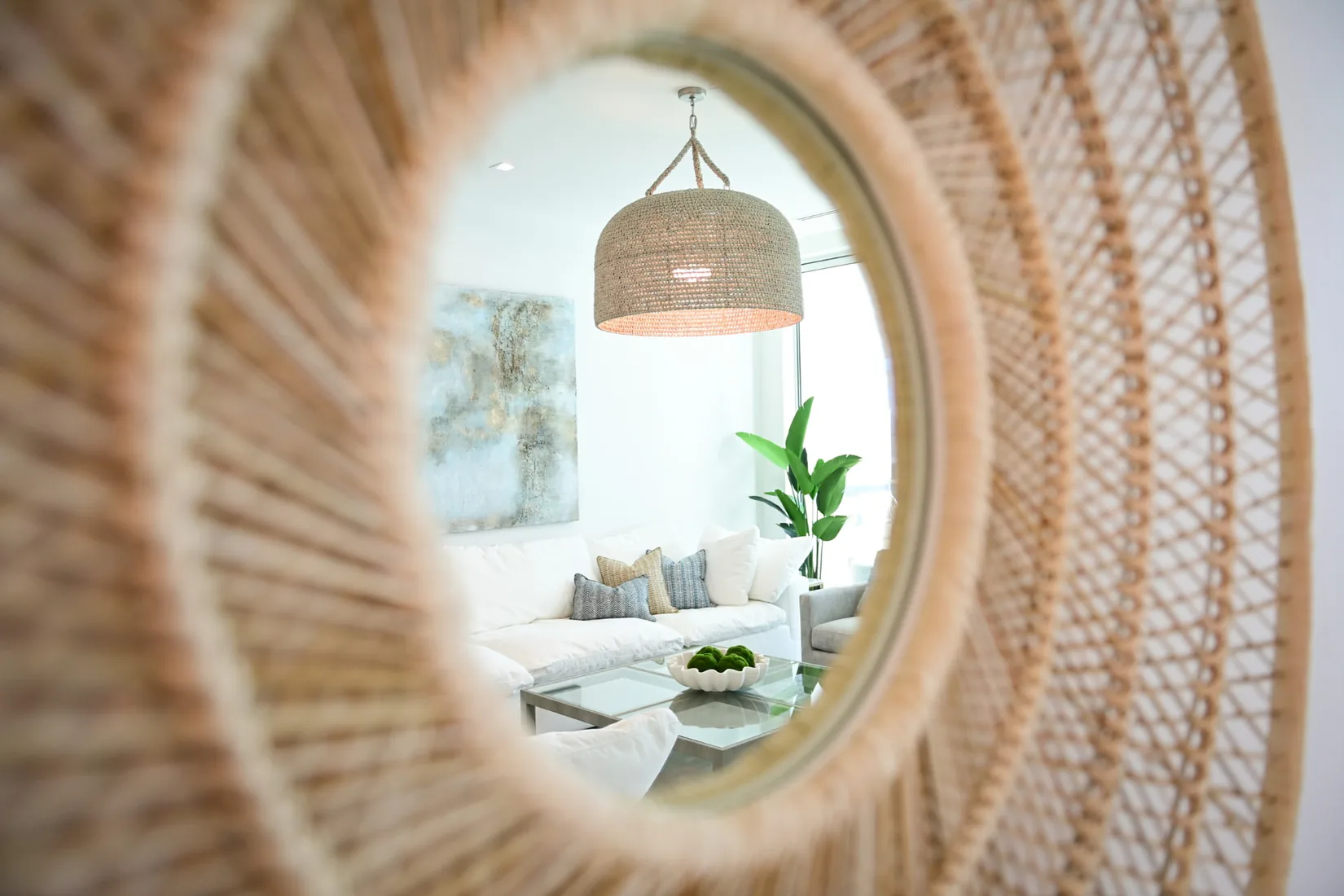 Living room seen through the reflection of a round rattan mirror in Grand Cayman