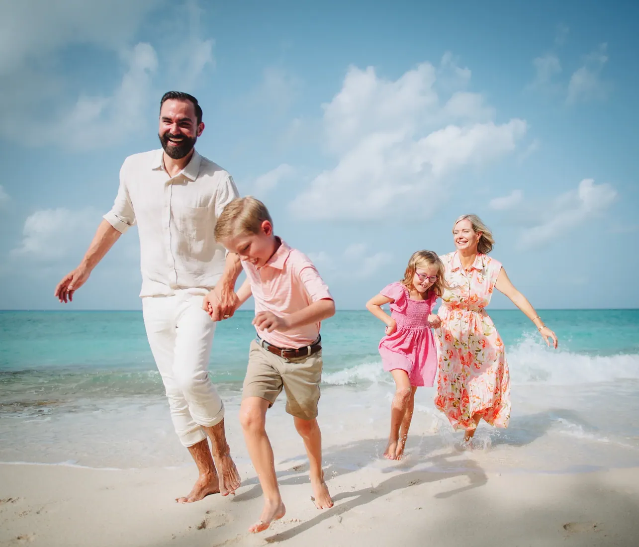 Family walking together in turquoise shallows in Grand Cayman