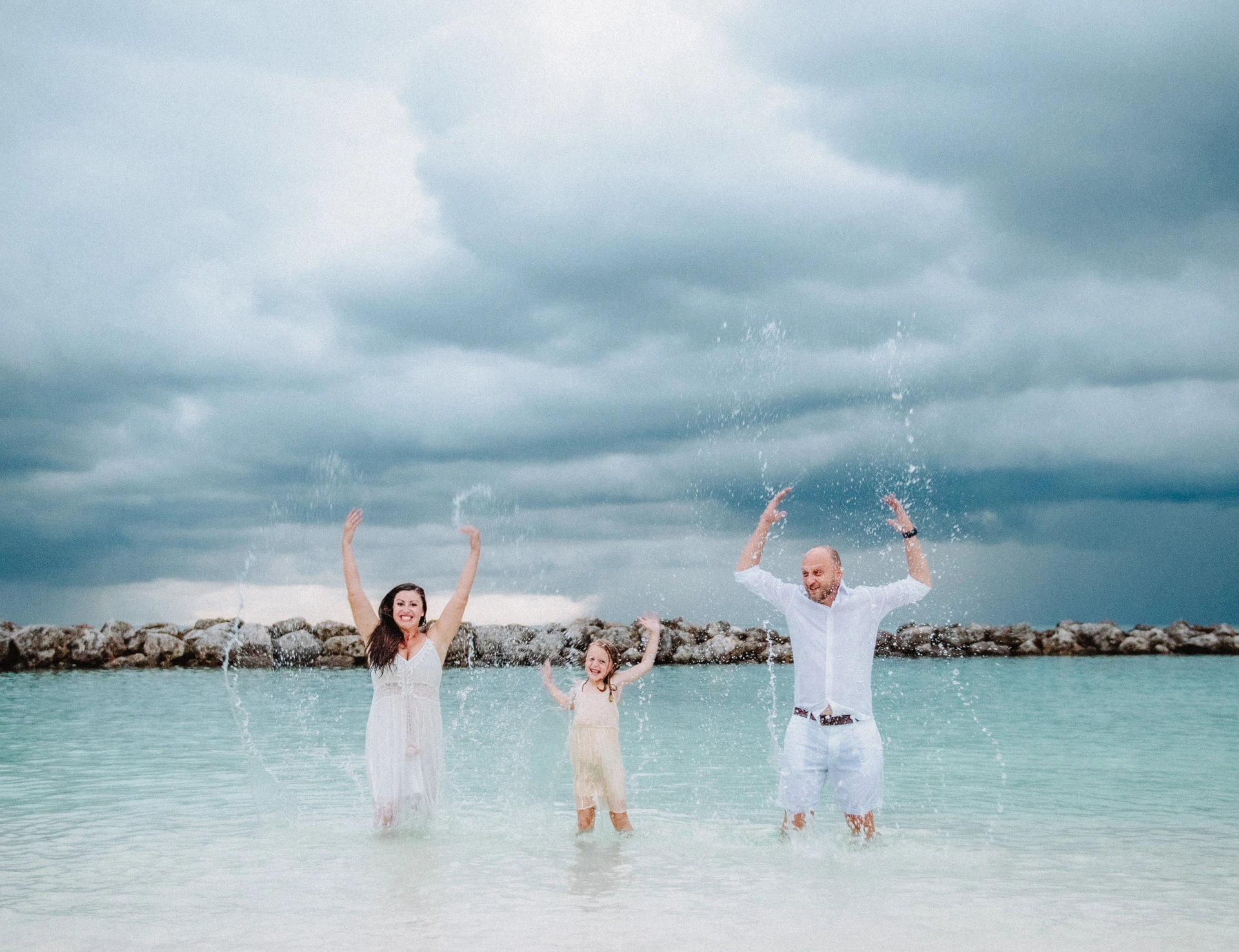 Family together beside the ocean during a cloudy Grand Cayman session