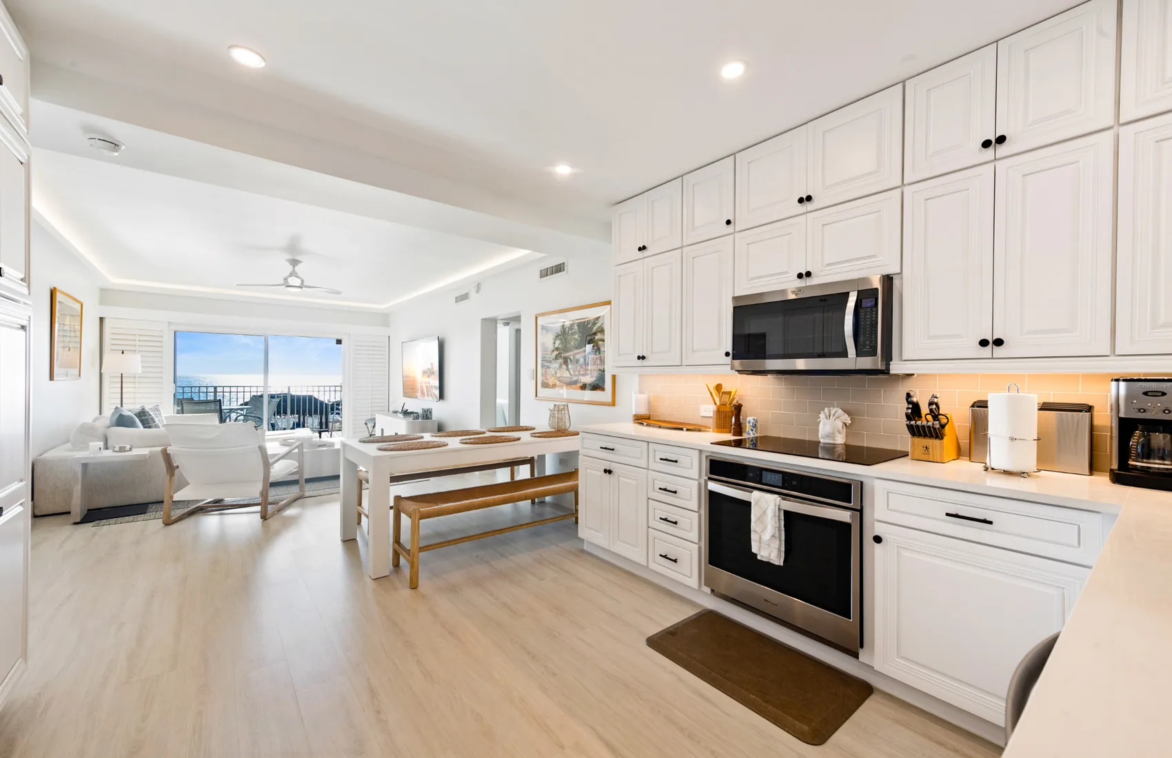 Open-plan kitchen, dining and living room with an ocean-view balcony in Grand Cayman