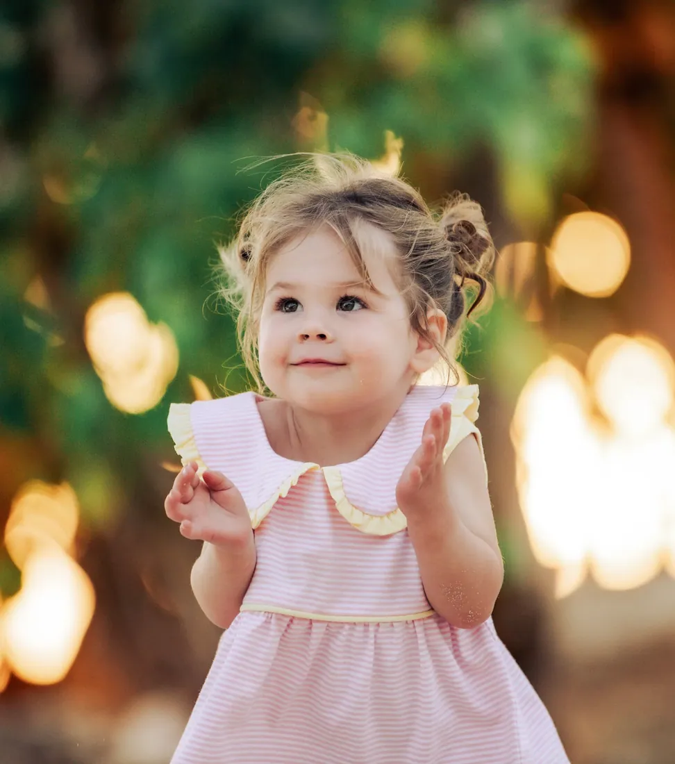 Little girl in a pink dress in warm garden light in Grand Cayman