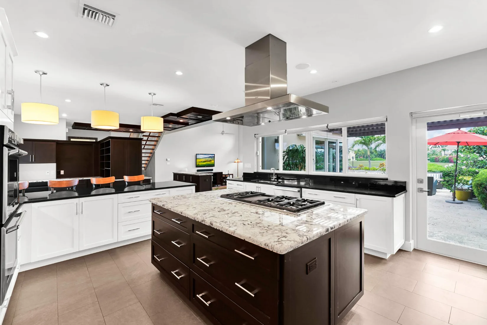 Kitchen with a dark wood island and yellow pendant lights in Grand Cayman